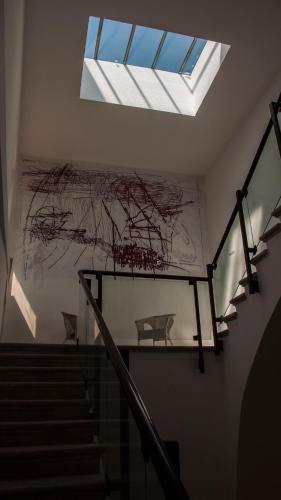a building with a skylight and stairs with a painting at Palazzo Verrone in Bari