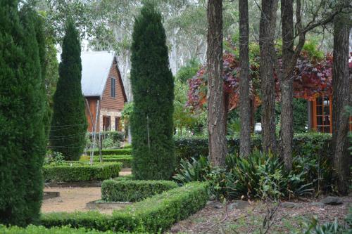 a garden in front of a house with trees and bushes at Thulanathi - Rest Explore Reconnect in Pokolbin