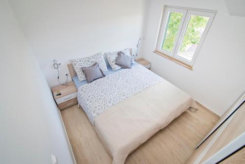 een slaapkamer met een groot bed en een raam bij Apartmani Daniela in Jezera