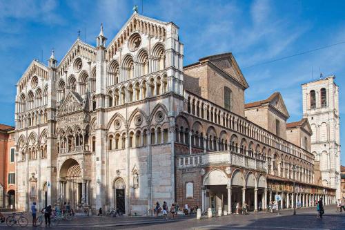 een groot gebouw met mensen die ervoor lopen bij Casa Belfiore Da Andrea in Ferrara