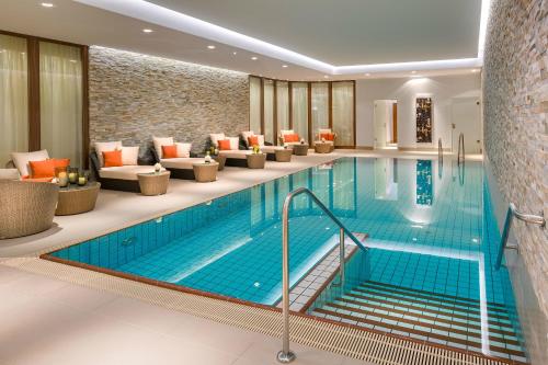 uma piscina no átrio do hotel com sofás e uma sala de espera em Breidenbacher Hof, Best Grandhotel 2024 - Die 101 Besten em Düsseldorf