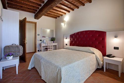 a bedroom with a large bed with a red headboard at Tenuta San Giovanni Lucca in Lucca