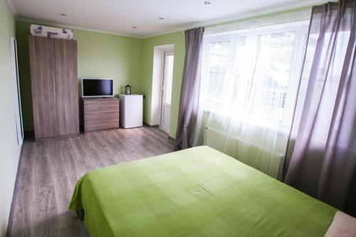 プリモルスコ・アフタルスクにあるHouse on Chernetskogoのベッドルーム(緑色のベッド1台、テレビ付)