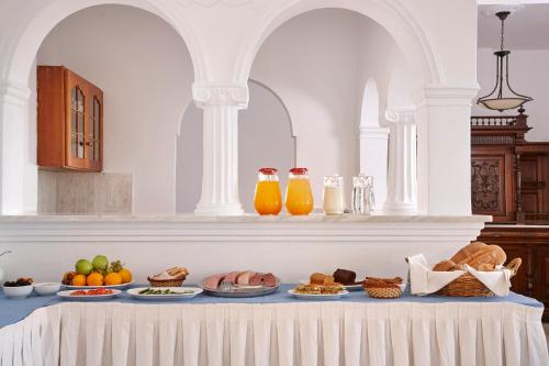 a table with plates of food and orange juice at Terra Blue Santorini in Kamari