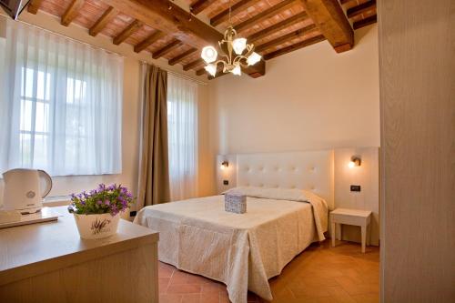 a bedroom with a bed and a table with flowers at Tenuta San Giovanni Lucca in Lucca