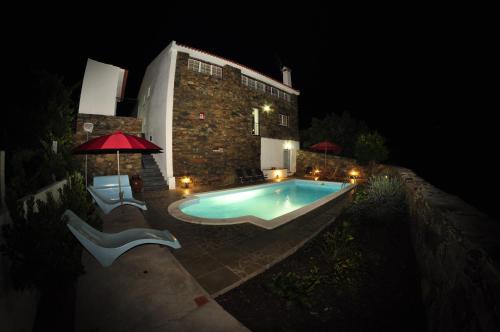 uma piscina em frente a um prdio  noite em Casa dos Hospitalrios em Alvaro