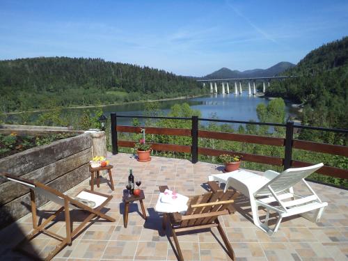 a patio with chairs and tables and a view of a river at Villa MOYA 1 in Fužine