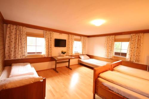 pokój z dwoma łóżkami, stołem i telewizorem w obiekcie Appartement Schmiedhof w mieście Zell am See