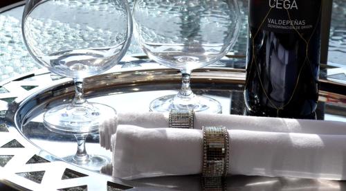una mesa con dos copas de vino y un reloj en Mediterranean Holidays, en Ierissos