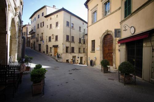 an empty street with buildings and potted plants in an alley at Dimora Dell'Erbe Rooms in Montepulciano