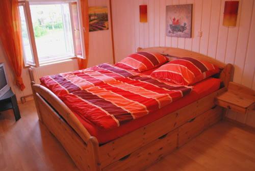 een bed met een rood en wit dekbed in een slaapkamer bij Salzachblick in Oberndorf bei Salzburg