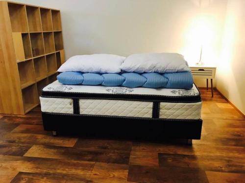 łóżko z niebiesko-białymi poduszkami na górze w obiekcie Óseyri Hlaðan -The Barn studio apartment w mieście Stöðvarfjörður