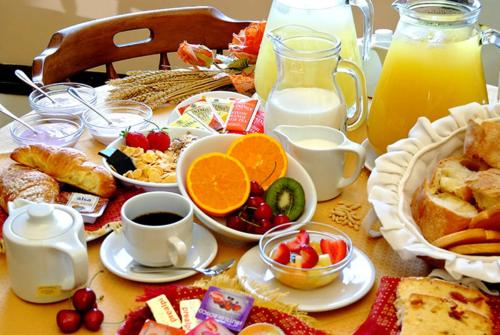 a table with a breakfast of fruit and bread and juice at Villa Lucrezia in Reggello