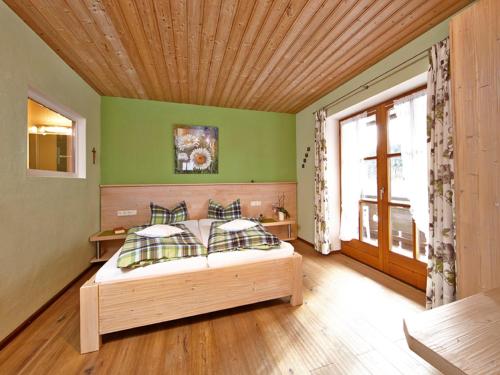 a bedroom with a bed with a wooden ceiling at Hotel am Wiesenhang - Garni in Bad Kohlgrub