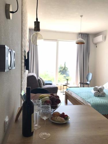 a room with a table with a bowl of fruit and wine glasses at VilaA21 in Bar