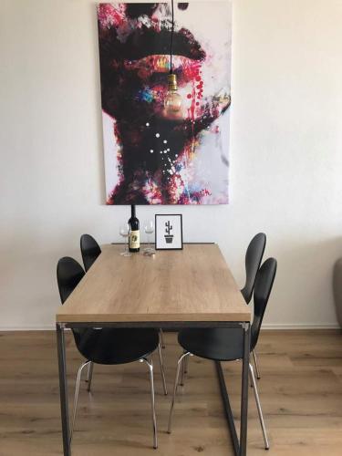 a dining room table with chairs and a painting at VilaA21 in Bar
