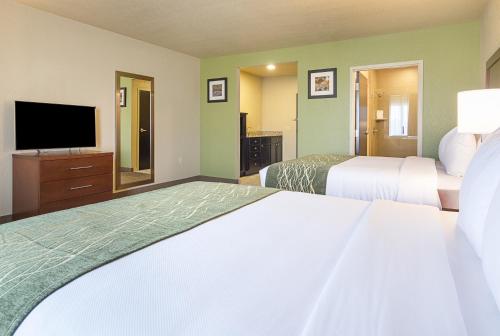 a hotel room with two beds and a flat screen tv at Comfort Inn Bentonville - Crystal Bridges in Bentonville