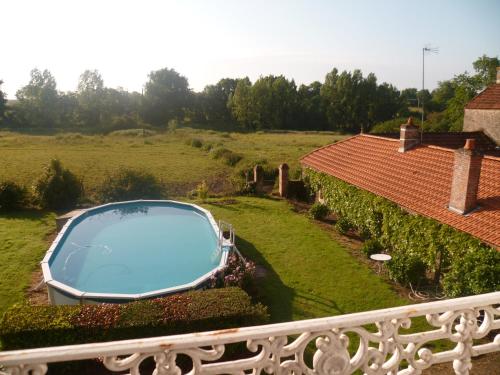 una piscina en un patio junto a una casa en Le Logis, en Les Pineaux