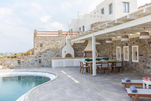 an external view of a villa with a swimming pool at Naxos Rock Villas in Stelida
