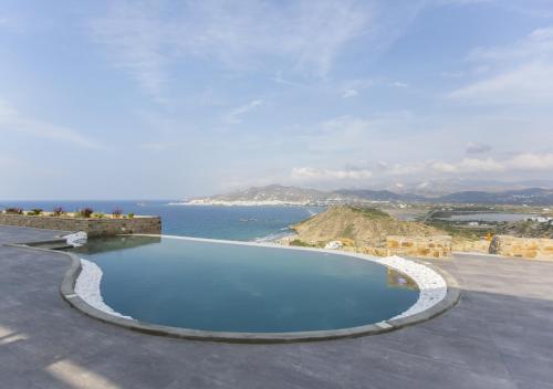 a swimming pool on top of a building with a view of the ocean at Naxos Rock Villas in Stelida