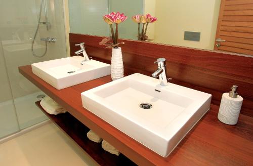 a bathroom with a white sink and a mirror at Amendoeira Golf Resort in Armação de Pêra
