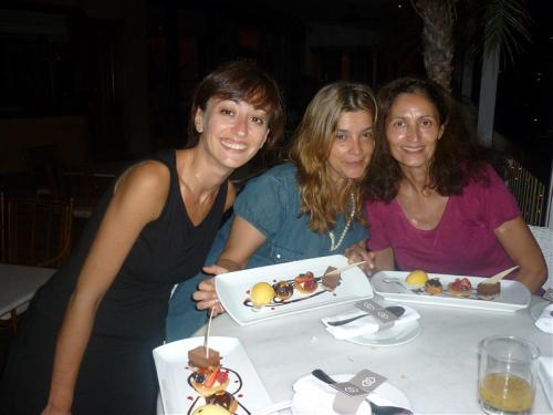 里約熱內盧的住宿－riosoleilcopacabana，三个女人坐在餐桌上,拿着一盘食物