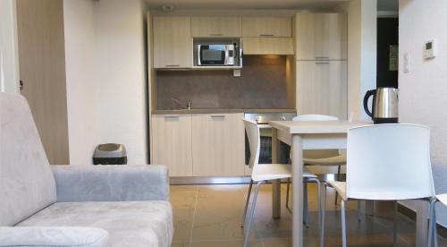 a kitchen and dining room with a table and chairs at Appart'hotel le Pèlerin in Lourdes