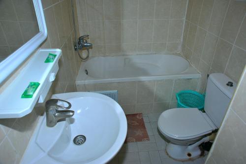 a white toilet sitting next to a tub in a bathroom at La Baraka Auberge in Aït Benhaddou