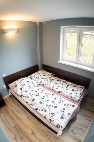 a bed sitting in a room with a window at Noclegi nad Soliną in Solina