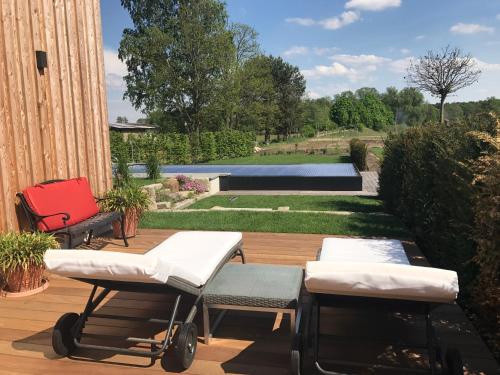 a patio with two chairs and a swimming pool at Alwine - Landhaus an den Spreewiesen in Rietz Neuendorf