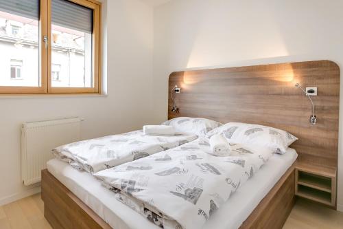 a bedroom with a large bed with a wooden headboard at Apartment Nova Cesta 62 in Zagreb