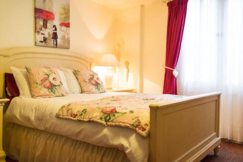 a bedroom with a bed with a floral bedspread at The Bell Hotel in Winslow