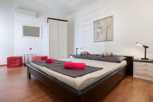 a bedroom with a large bed with red pillows on it at Villa Noa in Makarska
