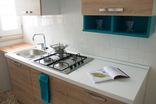 a kitchen counter with a stove and a sink at Appartamento La Vela in Lido Conchiglie
