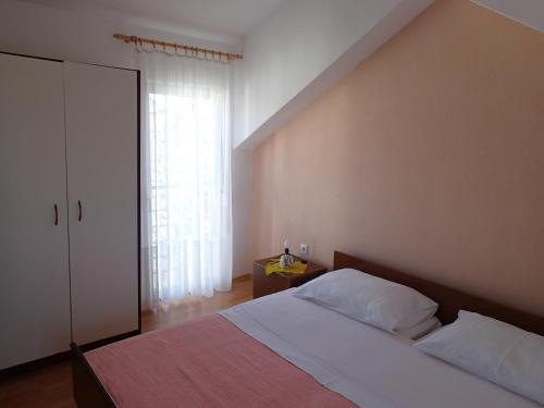 a bedroom with a bed and a large window at Apartments Violeta in Betina