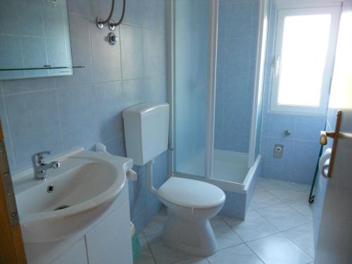 a bathroom with a toilet and a sink and a shower at Apartments Violeta in Betina