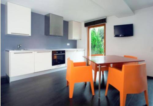 eine Küche mit einem Esstisch und orangefarbenen Stühlen in der Unterkunft Casa al Lido in Locarno