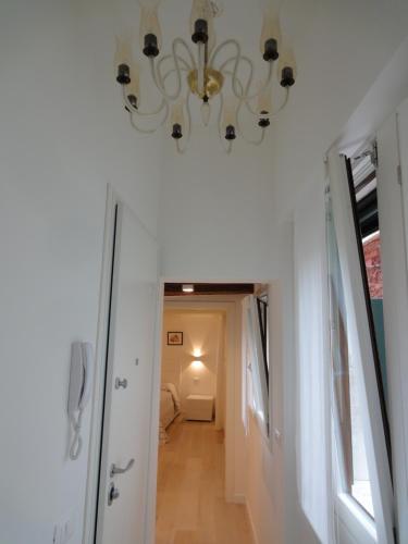 un corridoio con un lampadario pendente appeso a un soffitto di Appartamento San Tomà a Venezia