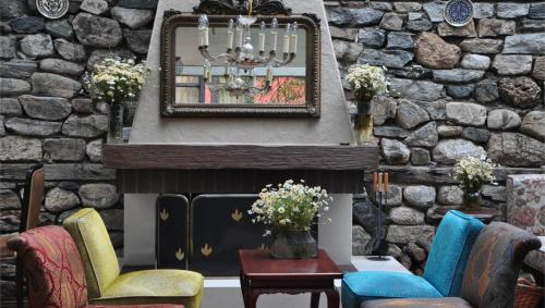 a living room with a fireplace with chairs and a mirror at Kitapevi Hotel in Bursa