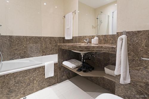 a bathroom with a sink and a bath tub and a sink at Santa Catarina l by An Island Apart in Funchal
