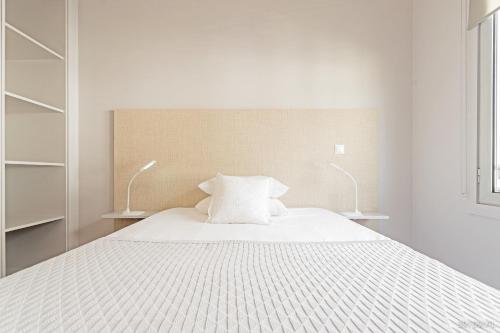 a white bedroom with a bed with two lamps at Santa Catarina l by An Island Apart in Funchal