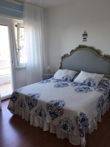 una camera con un letto con copriletto blu e bianco di L`attico di Anna a Sanremo