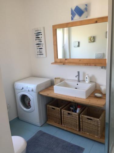 ein Badezimmer mit einer Waschmaschine und einem Waschbecken in der Unterkunft L`attico di Anna in Sanremo