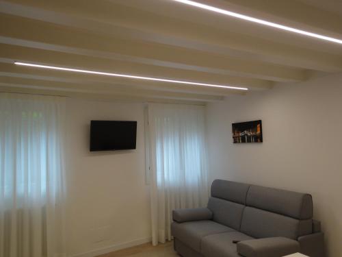 a living room with a couch and a flat screen tv at Appartamento San Tomà in Venice