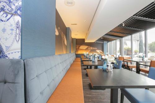 a dining room with tables and chairs at Fletcher Hotel-Restaurant Leidschendam – Den Haag in Leidschendam