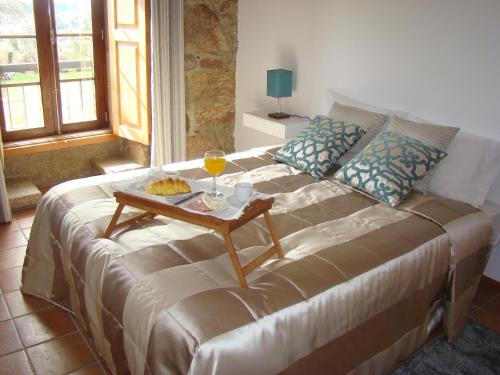 ein Bett mit einem Tablett mit Essen und einem Tisch darauf in der Unterkunft Casa de Campo Patio do Avo in Routar
