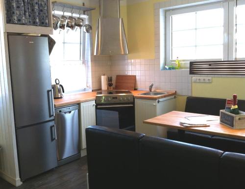 a kitchen with a stainless steel refrigerator and a stove at Reetdachhaus Strandecke in Freest