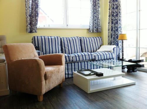 a living room with a couch and a coffee table at Reetdachhaus Strandecke in Freest