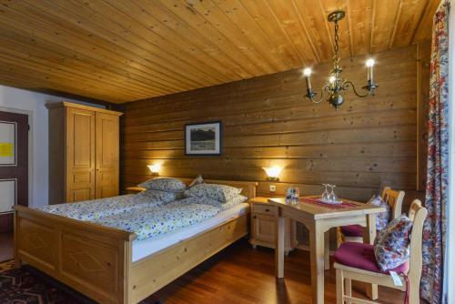 een slaapkamer met een bed en een houten muur bij Schmied von Kochel in Kochel