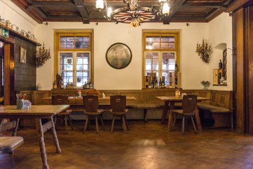 a restaurant with wooden tables and chairs and a chandelier at Schmied von Kochel in Kochel